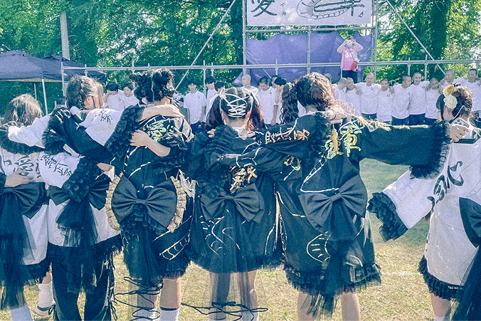 体育祭の時の写真です。お揃いのオリジナルの衣装を着た大勢の生徒が円陣を組んでいます