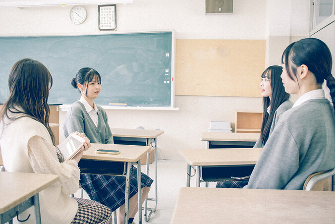 ライターと在校生3人が向かい合って座っている写真です。和やかにインタビューを受けています。