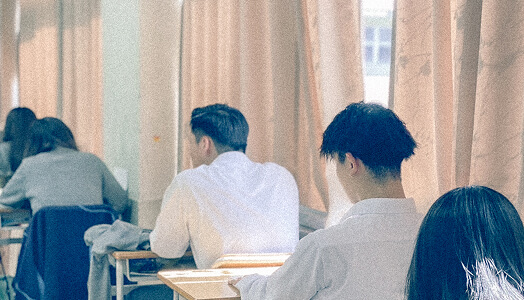 教室で真剣に授業を受ける生徒たちの後ろ姿です。