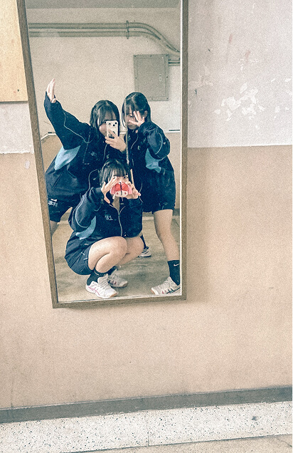 3人の生徒が鏡の前で自撮りをしています。