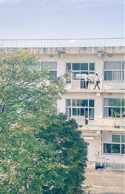 ベランダを歩く生徒を屋外から撮影した写真です。